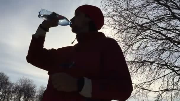 Silhouette de sportif boit de l'eau d'une bouteille . — Video