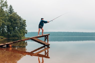 Adam gölde olta atar.