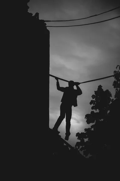 Silhouet van een man zijn handen op het touw te verplaatsen. — Stockfoto