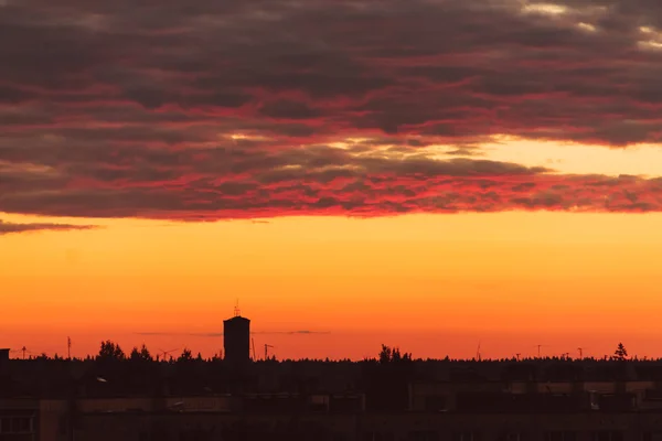 タワーのシルエットを背景に夕日とオレンジ色の空. — ストック写真