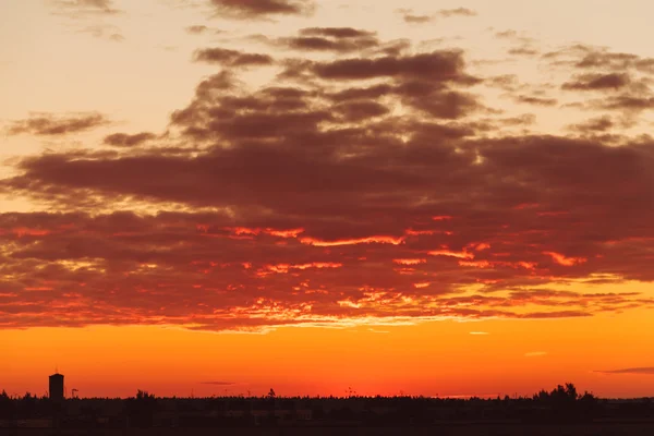 タワーのシルエットを背景に夕日とオレンジ色の空. — ストック写真