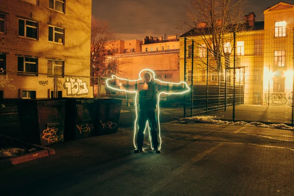 People circled the glowing wire at night in the courtyard. — Stock Photo, Image