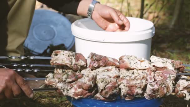 Pedaços de carne pendurados à mão humana em um espeto . — Vídeo de Stock