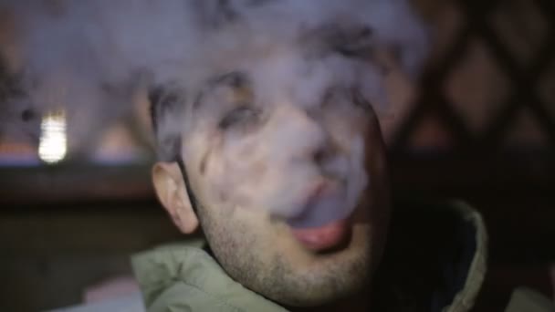 Jeune homme laisse sortir une fumée d'une bouche et puis clin d'oeil . — Video