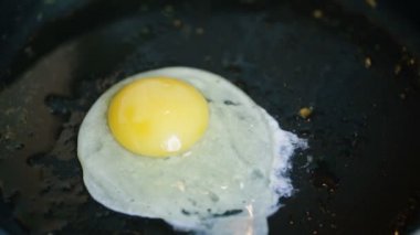 Bir kızartma tavası ve yavru bir yumurta kırmak.