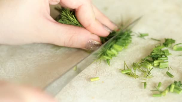 Γυναικεία χέρια ένα πράσινο μάραθο κομμένα σε μικρά κομμάτια. — Αρχείο Βίντεο