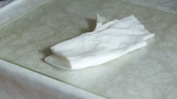 Белая кухонная тряпка лежит на столе . — стоковое видео