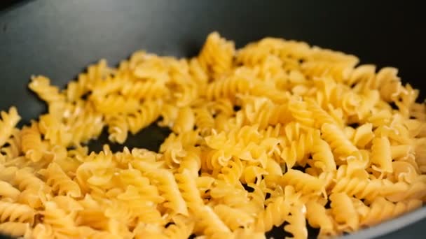 I maccheroni aggiungono a una padella per friggere allora mescola una pala di legno . — Video Stock