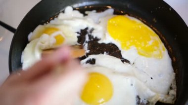 El ahşap bir spatula ile bir tavada yumurta engeller.