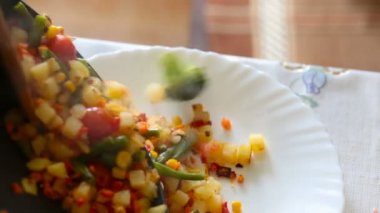 Sıcak vejetaryen salata dökün beyaz tabak içinde.