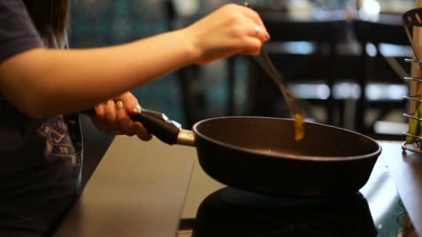 Las manos femeninas manejan la sartén y hábilmente corrigen la comida por el tenedor . — Vídeo de stock