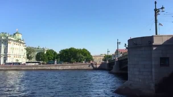 Camera si muove a sinistra sulla destra lungo il fiume a neva e rimuove la bellezza di San Pietroburgo galleggiante sotto il ponte nel pomeriggio . — Video Stock