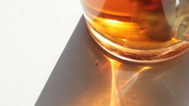 Siyah çay cam kabı dibinde beyaz masa ve bir küçük midge bir görünümü ile karıştırılır.