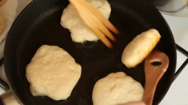 Erkek flip krep tahta spatula ile bir tavada kızarmış eller.