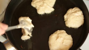 Krep bir tencerede kızartılır ve el hamur başka bir kısmını tava içine ekler..