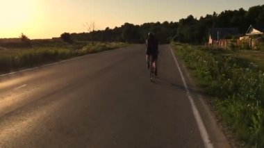 Kişi asfalt dikiz kamera üzerinde bisiklet arkasına taşır bir spor sürmek.