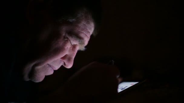 Ηλικιωμένος άνδρας σερφάροντας στο interente βράδυ στο υπολογιστή tablet. — Αρχείο Βίντεο