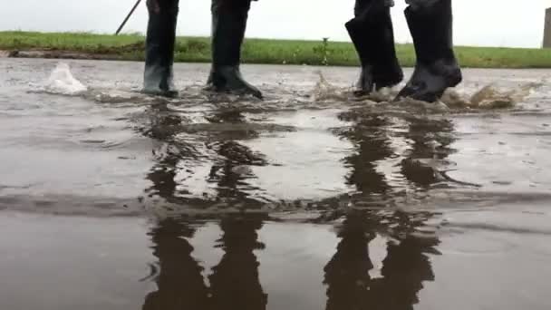 Pulando juntos em uma poça câmera lenta — Vídeo de Stock