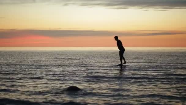 Hombre tonteando en el mar al atardecer — Vídeos de Stock