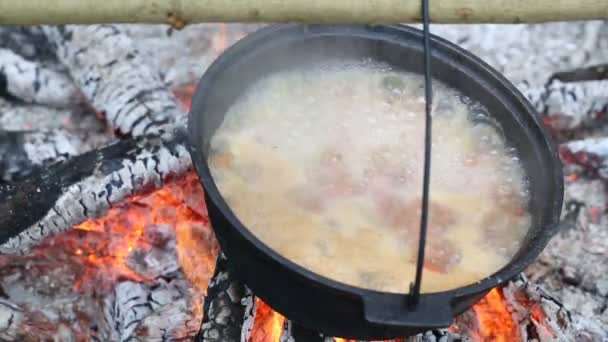Μαγειρεύοντας σούπα σε μια κατσαρόλα στη φωτιά — Αρχείο Βίντεο