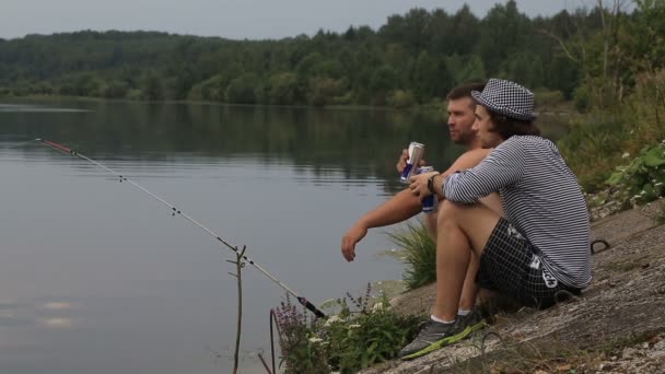 Two friends on a fishing trip drink soft drinks and talk — Stock Video