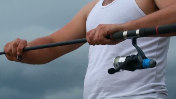 Unga fiskare konfigurerar hans fiskespö — Stockvideo