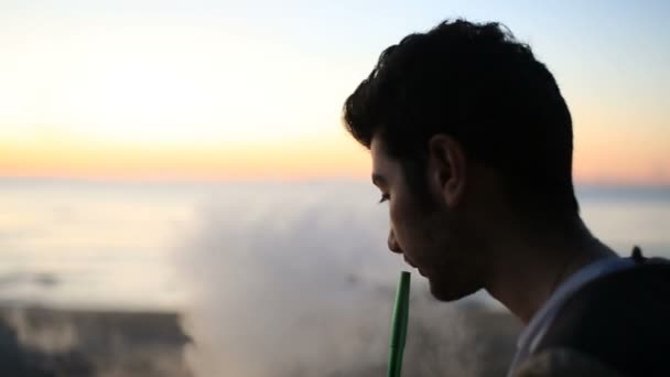 Человек курит кальян на открытом воздухе — стоковое видео
