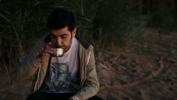Jeune homme buvant du thé en plein air le soir — Video