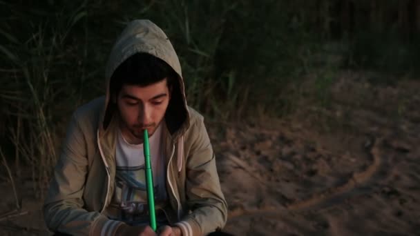 Man smokes a hookah outdoor — Stock Video