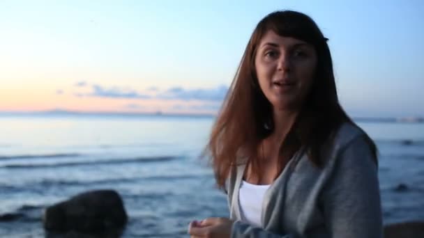 Young beautiful girl posing on the beach in the evening — Stock Video