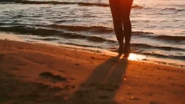 Kız plajda keyif için günbatımı sırasında atlama