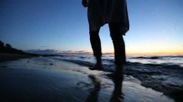 Девушка гуляет по пляжу после заката — стоковое видео