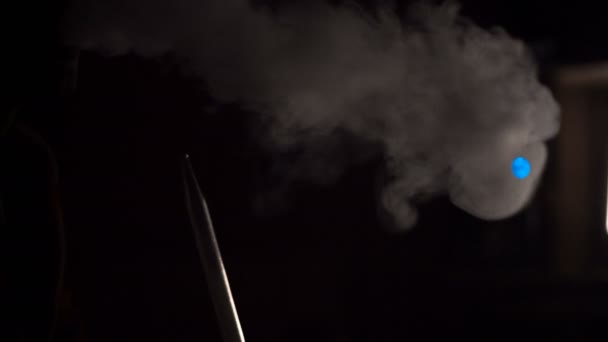 Mann raucht Wasserpfeife in einem dunklen Raum — Stockvideo