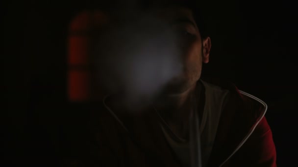 Muž kouří vodní dýmky v temné místnosti — Stock video