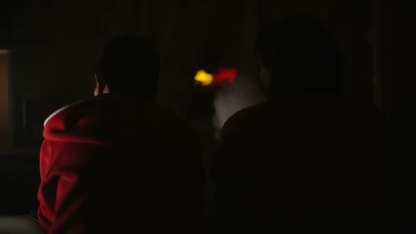 Deux amis qui parlent et fument du narguilé. Vue de l'arrière. style noir .