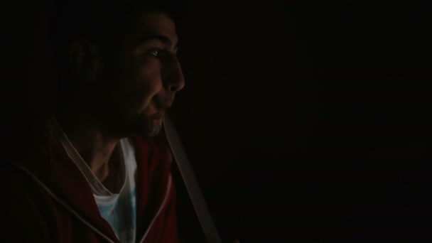 El hombre fuma narguile en una habitación oscura — Vídeo de stock