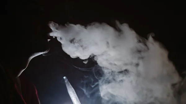 Homem fuma no escuro — Fotografia de Stock