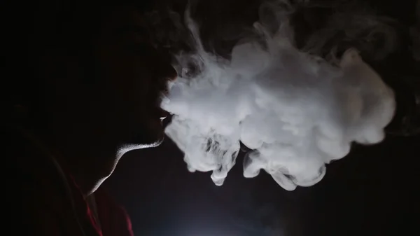 El hombre fuma en la oscuridad — Foto de Stock