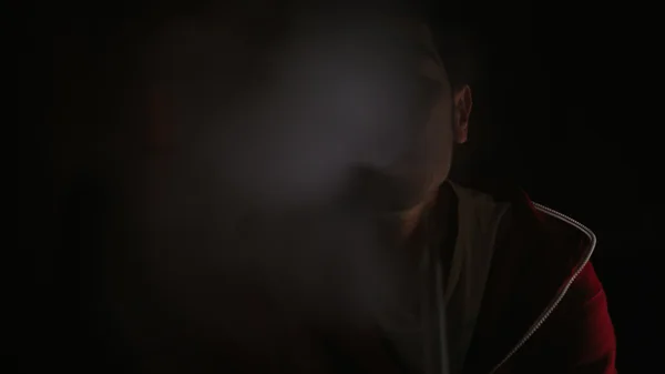 Homem fuma no escuro — Fotografia de Stock