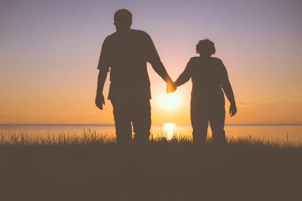 Senior couple holding hands silhouettes — Stock Photo, Image