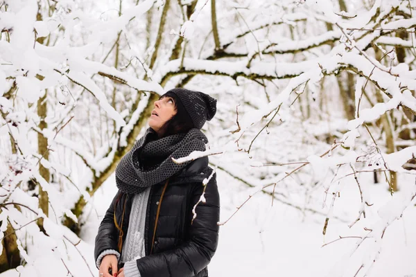 Girl stares up in the winter forest — Stock Photo, Image