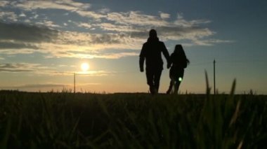 Genç bir çift el ele tutuşarak silüeti