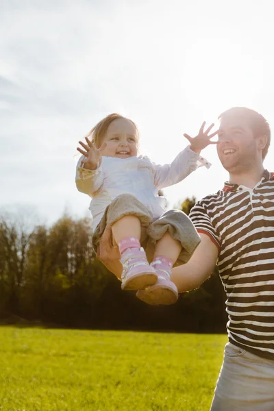 Kleines Mädchen sitzt auf dem Arm ihres Vaters — Stockfoto