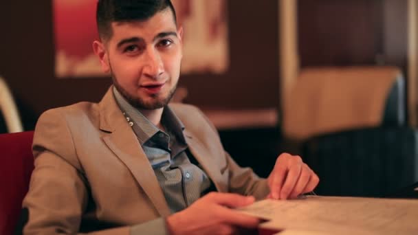 Giovane uomo d'affari che conduce una conversazione d'affari nel caffè — Video Stock