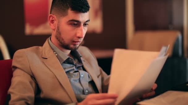 Молодой человек бизнесмен ведет деловую беседу в кафе — стоковое видео