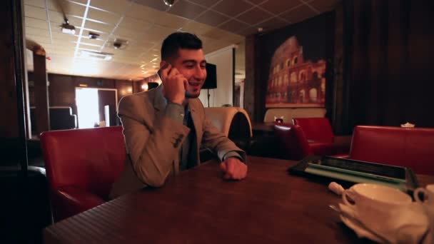 Ung affärsman på telefonen i café — Stockvideo