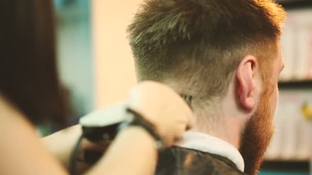 Barber zastřihne vlasy klienta s clipper. — Stock video