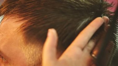 Makas ile çalışan Kuaför ve genç bir adam keser.