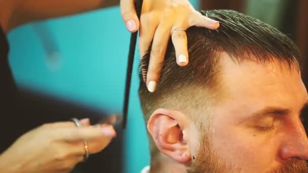 Friseur arbeitet mit Schere und schneidet jungen Mann. — Stockvideo