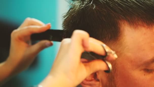 Friseur arbeitet mit Schere und schneidet jungen Mann. — Stockvideo